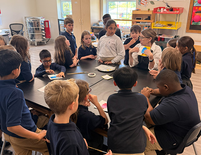Small group of students gathered around a table with their teacher